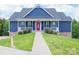 Charming blue two-story home with a red front door and white railings leading to a well-manicured lawn at 7768 Pinecone Ln, Hickory, NC 28602