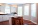 Bright, contemporary kitchen featuring white cabinetry, an island with seating, and hardwood floors at 7768 Pinecone Ln, Hickory, NC 28602