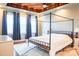 Comfortable main bedroom boasts a four-poster bed, tray ceiling, and soft natural light at 7768 Pinecone Ln, Hickory, NC 28602