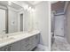 Bathroom with double vanity, gray cabinets, marble floors, and a neutral color palette at 7908 Rea View Ct, Charlotte, NC 28226