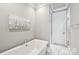 Bathroom featuring a freestanding tub, marble floors, and a clean, modern design at 7908 Rea View Ct, Charlotte, NC 28226