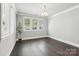 Bright bedroom with hardwood floors, large windows, white walls, and modern chandelier at 7908 Rea View Ct, Charlotte, NC 28226
