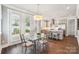Dining area showcasing an elegant chandelier, glass table and view into the adjacent kitchen at 7908 Rea View Ct, Charlotte, NC 28226