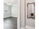 Hallway with hardwood floors, gray walls, white trim, and a glimpse into an adjacent room with a chandelier at 7908 Rea View Ct, Charlotte, NC 28226