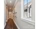 Hallway with hardwood floors, gray walls, white trim, and shelves with decorative items at 7908 Rea View Ct, Charlotte, NC 28226