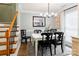 Cozy dining room with a white table, seating for six, with a modern chandelier and staircase at 8532 Piccone Brook Ln, Charlotte, NC 28216