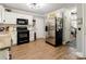 Kitchen showcasing stainless steel appliances, white cabinetry, and hardwood flooring at 8532 Piccone Brook Ln, Charlotte, NC 28216
