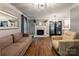 Cozy living room with a fireplace, hardwood floors, and lots of natural light at 8532 Piccone Brook Ln, Charlotte, NC 28216