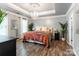 Luxurious bedroom with a chandelier, accent wall, and tray ceiling at 8532 Piccone Brook Ln, Charlotte, NC 28216
