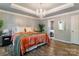 Elegant bedroom featuring hardwood floors, a chandelier, and panel accent wall at 8532 Piccone Brook Ln, Charlotte, NC 28216