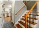 View of a wood staircase with black wrought iron spindles and view into the kitchen at 8532 Piccone Brook Ln, Charlotte, NC 28216