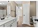 Bathroom features a white vanity, a toilet and a view into the bathroom with shower-tub at 8610 Sawleaf Ct, Charlotte, NC 28215