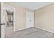 Bedroom featuring neutral carpet and trim, with ample closet space and a view into the hallway at 8610 Sawleaf Ct, Charlotte, NC 28215