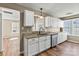 Bright kitchen features white cabinets, granite countertops, stainless steel appliances, and wood-look flooring at 8610 Sawleaf Ct, Charlotte, NC 28215