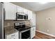 Modern kitchen featuring stainless appliances, granite countertops, and white cabinetry at 8610 Sawleaf Ct, Charlotte, NC 28215