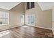 Light-filled living room with hardwood floors, large windows, and vaulted ceiling at 8610 Sawleaf Ct, Charlotte, NC 28215