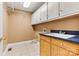 Functional laundry room with ample cabinet space, a utility sink, and tiled flooring at 9561 Island Point Rd, Sherrills Ford, NC 28673
