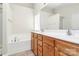 Bathroom with double sink vanity, soaking tub, and large mirror at 10606 Gallowgate Ln, Charlotte, NC 28213