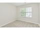 Neutral carpeted bedroom featuring one large window bringing in natural light at 10606 Gallowgate Ln, Charlotte, NC 28213