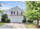 Charming two-story home featuring a two-car garage, red shutters, and landscaped front yard at 10606 Gallowgate Ln, Charlotte, NC 28213