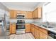 Well-lit kitchen featuring stainless steel appliances, granite countertops, and wood cabinets at 10606 Gallowgate Ln, Charlotte, NC 28213