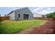 Large backyard with gray exterior and wooden fence on both sides at 107 S Sina St, Troutman, NC 28166