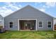 View of home's rear exterior with a covered patio and ample yard space at 107 S Sina St, Troutman, NC 28166