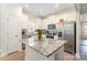 Modern kitchen with white cabinets, stainless steel appliances, granite countertops, and large kitchen island at 107 S Sina St, Troutman, NC 28166
