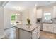 Well-lit eat-in kitchen with an island and stainless steel appliances, perfect for Gathering meals and entertaining at 107 S Sina St, Troutman, NC 28166