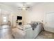 Comfortable living room with a gray sectional sofa, fireplace, mounted television, and pet gate at 107 S Sina St, Troutman, NC 28166
