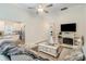 Comfortable living room with a gray sectional sofa, fireplace, mounted television, and an open view to the kitchen at 107 S Sina St, Troutman, NC 28166