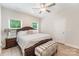 Bedroom with natural light from dual windows, featuring a ceiling fan and neutral color scheme for peaceful rest at 107 S Sina St, Troutman, NC 28166