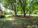 Backyard featuring mature shade trees, a picnic table, and a storage shed at 1111 Unionville Church Rd, Monroe, NC 28110