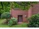 Close-up of basement access with brick surround and blooming shrubbery at 1136 S Edgemont Ave, Gastonia, NC 28054