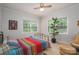 Cozy bedroom featuring a colorful bedspread, ceiling fan, and natural light from the windows at 1136 S Edgemont Ave, Gastonia, NC 28054