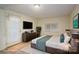 Stylishly staged bedroom features a comfortable bed, modern dresser, and natural light from the window at 1136 S Edgemont Ave, Gastonia, NC 28054