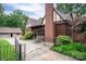 Side view of brick home showcasing attached garage, quaint seating area and lush, well-manicured landscaping at 1136 S Edgemont Ave, Gastonia, NC 28054