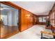 Inviting living room featuring wood paneling, hardwood floors, and an adjacent room at 1136 S Edgemont Ave, Gastonia, NC 28054