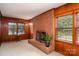 Cozy living room with a brick fireplace, wood paneling, carpet and natural light from the windows at 1136 S Edgemont Ave, Gastonia, NC 28054
