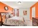 Cozy bedroom featuring warm orange accent wall, carpet flooring, and a decorative mirror at 12217 Dearview Ln, Charlotte, NC 28269