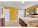 Bright bedroom featuring yellow accent wall, carpet flooring, and natural light at 12217 Dearview Ln, Charlotte, NC 28269