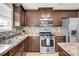 Kitchen features stainless steel appliances, dark wood cabinets, and tiled backsplash at 12217 Dearview Ln, Charlotte, NC 28269