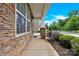 Inviting front porch with stone pillars and siding, offering a glimpse of the neighborhood street at 12217 Dearview Ln, Charlotte, NC 28269