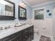 Bathroom featuring a double vanity with marble countertop and square black framed mirrors at 1227 Seneca Pl, Charlotte, NC 28210