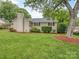 Charming single story home featuring a brick chimney, lush lawn, and mature trees for added curb appeal at 1227 Seneca Pl, Charlotte, NC 28210