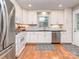 Modern kitchen features stainless steel appliances, white cabinets, hardwood floors, and plenty of countertop space at 1227 Seneca Pl, Charlotte, NC 28210
