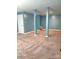 A spacious unfinished basement with neutral carpet and painted blue walls provides a blank canvas for customization at 12304 Sandringham Pl, Charlotte, NC 28262