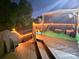 Enjoy this outdoor deck with covered seating and string lights, perfect for evening relaxation at 12304 Sandringham Pl, Charlotte, NC 28262