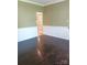 A living room with dark wood floors, light green walls, and white trim, complemented by an open doorway at 12304 Sandringham Pl, Charlotte, NC 28262