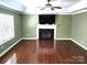 Living room with green walls, a fireplace, and hardwood floors at 12304 Sandringham Pl, Charlotte, NC 28262